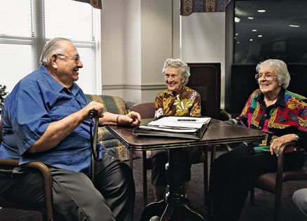 three senior citizens sitting around a table