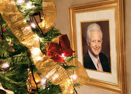 A photo portrait of Rick Moore's father next to a fully decorated Christmas tree