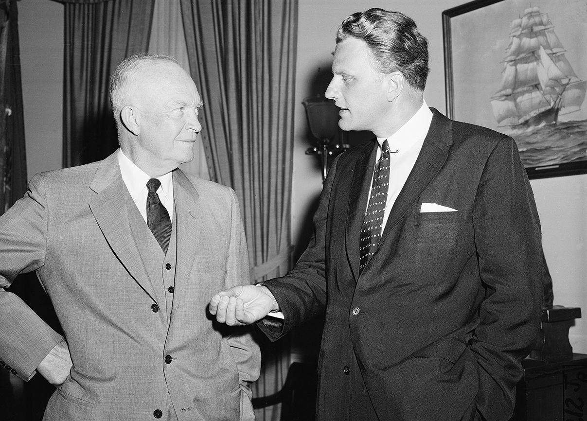 Graham talks with U.S. President Dwight Eisenhower (left) during a visit to the White House on May 10, 1957.