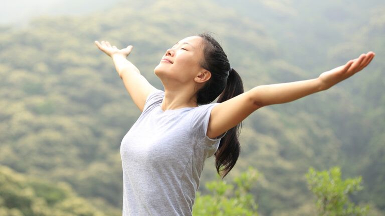 A woman raises her arms in praise