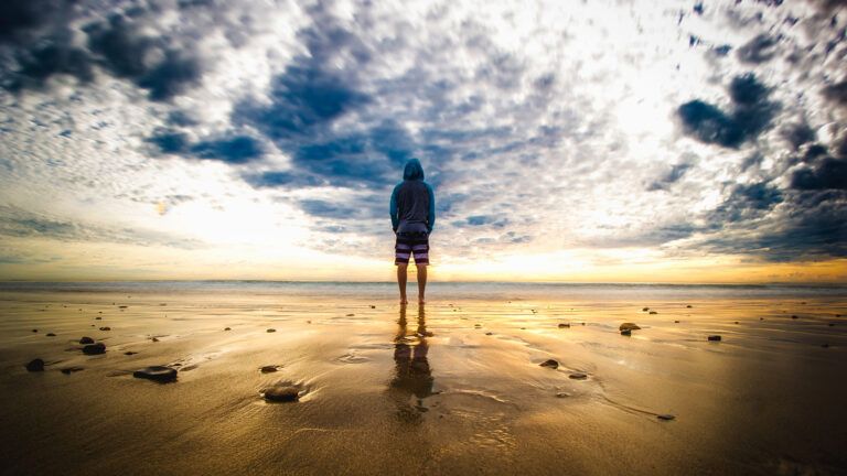 Teenager watching the sunrise at the beach