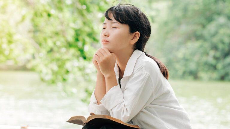 A woman prays in the outdoors