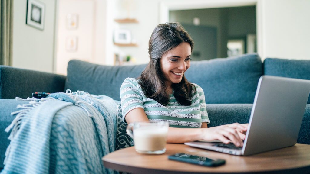 Young woman smiling at her laptop