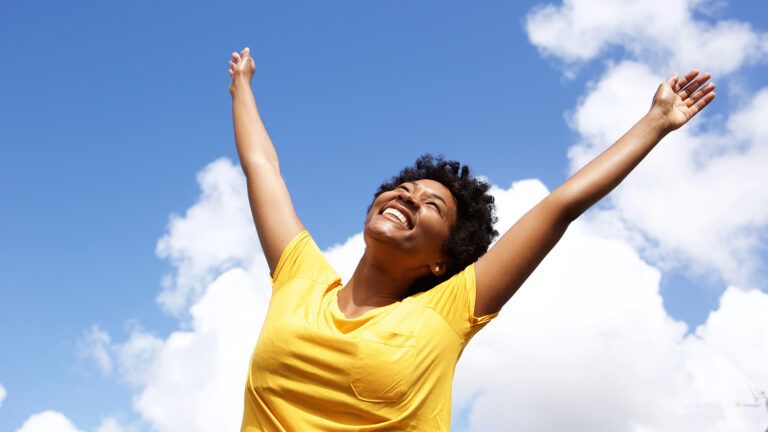 A woman raises her arms in joy